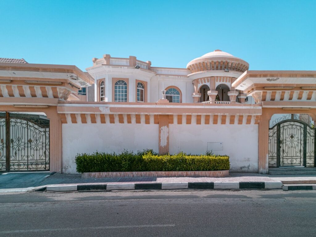 Elegant Mediterranean-style villa facade with ornate architecture and gated entrance.